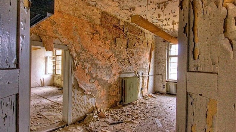 Im früheren Männerkrankengebäude C 20 sieht es nicht mehr besonders gemütlich aus. Die Tapete rollt sich von den Wänden, überall blättert Farbe ab.