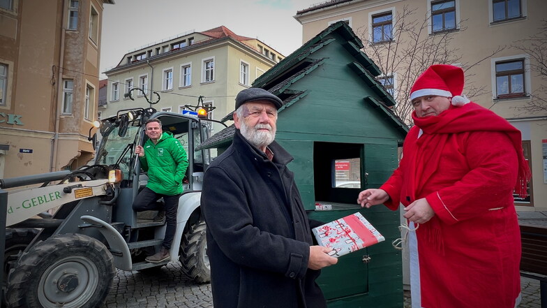 Die Kamenzer Stadtwerkstatt stellt nach einjähriger Pause wieder ihren Wichtelautomaten auf dem Markt auf. Weihnachtsmann Thomas Wolff, Günther Tschentscher und Sandro Gebler (v.r.) packten am Mittwoch mit an.