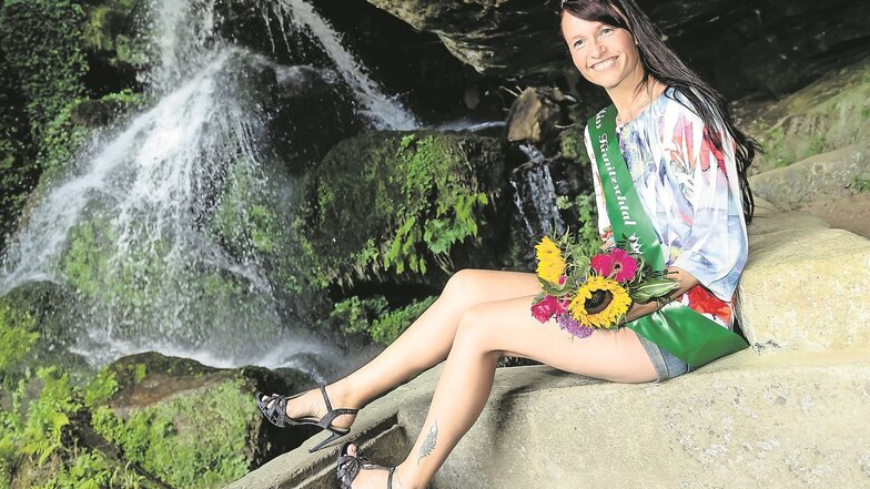 Die 39-jährige Manuela mit Krönchen und Schärpe vor dem Lichtenhainer Wasserfall. Kurz vor 17 Uhr war sie am Samstag zur schönsten Frau des Kirnitzschtals gewählt worden.