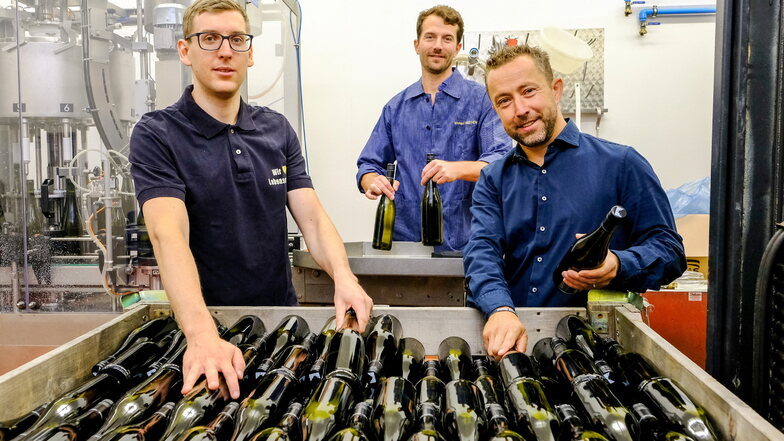 Im Weingut Drei Herren füllten Azubi Kevin Grune (v.l.n.r.) mit Kellermeister Jacob Wiedemann und Edeka-Marktinhaber John Scheller den Wein in Flaschen ab.