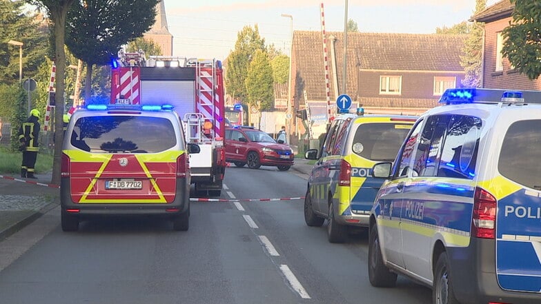 Einsatzkräfte stehen vor dem Bahnübergang, auf dem ein 14-jähriges Mädchen in Rees getötet wurde.