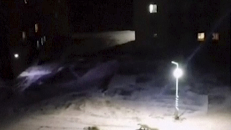 In diesem Video-Standbild laufen eine Eisbärin und zwei Jungen über den Innenhof eines Wohnblocks in Beluschja Guba. 