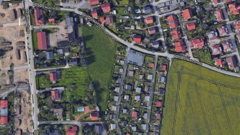 Blick auf das Areal an der Bernhard-Muth-Straße: Die Wiese in Dreiecksform in der Bildmitte soll ein neues Eigenheimgebiet werden.