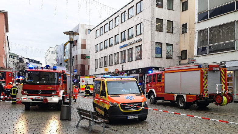 Einsatzkräfte von Feuerwehr und Rettungsdienst stehen in der Passauer Innenstadt am Einsatzort.