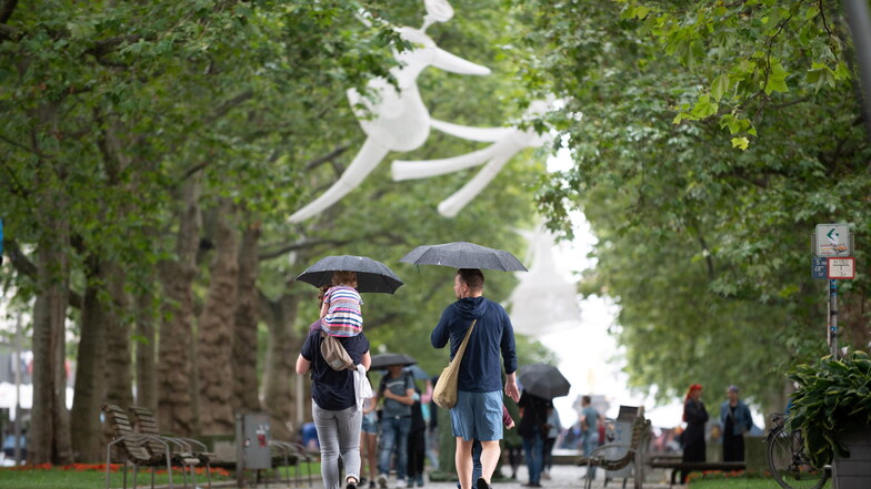 Figuren aus Stoff des Künstler- und Liebespaares Muriel & César aus Chile hängen im Rahmen des Schaubudensommers 2021 in den Bäumen der Hauptstraße.