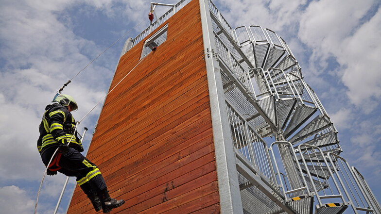 Gruppenführer Matthias Streiber demonstriert das Abseilen vom neuen Übungsturm aus acht Meter Höhe. Dieser Turm, auf dem auch das Retten über Treppen und aus Abwasserschächten trainiert werden kann, sucht im Landkreis Meißen seinesgleichen.
