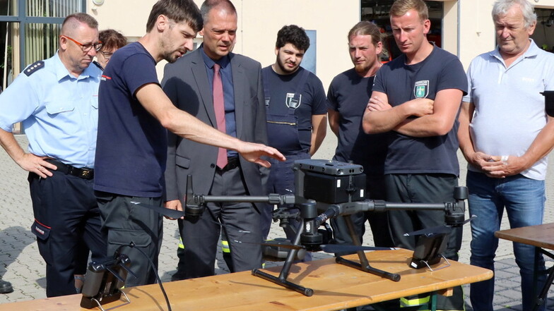 Der Radeburger Stadtwehrleiter Marcus Mambk erläutert Landrat Ralf Hänsel und den Glaubitzer Kameraden die Vorzüge der neuen Drohne.