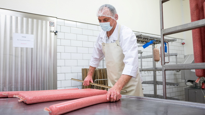 Ein Mitarbeiter der Niederschlesischen Wurstmanufaktur Görlitz hängt die frisch hergestellten Salami in einen speziellen Wagen, mit dem es in die Reifekammer geht.