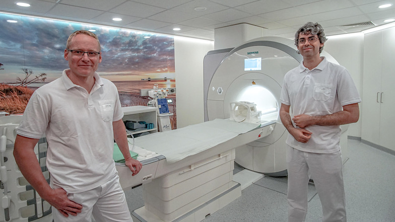 Die Radiologen Thomas Stenzel (l.) und Can Onaygil zeigen das neue Magnetresonanztomografie-Gerät (MRT) im Bautzener Krankenhaus. Es ist breiter und kürzer als übliche MRT-Geräte und kann besonders detaillierte Aufnahmen machen.