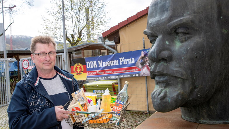 Conny Kaden vom DDR-Museum Pirna zeigt einen DDR-Warenkorb mit Lebensmitteln.
