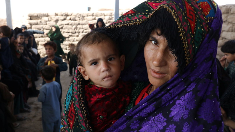 Afghanistan, Herat: Eine Mutter und ihr Kind sitzen in einer Ernährungsklinik in der Nähe eines Vertriebenenlagers am Stadtrand. Die Hälfte der afghanischen Bevölkerung ist von akutem Hunger bedroht.