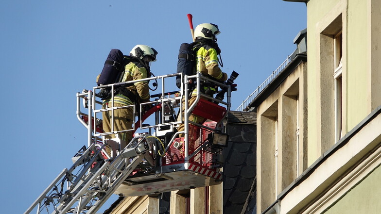 Feuerwehrleute vor der Wohnung im Dachgeschoss des Mehrfamilienhauses.