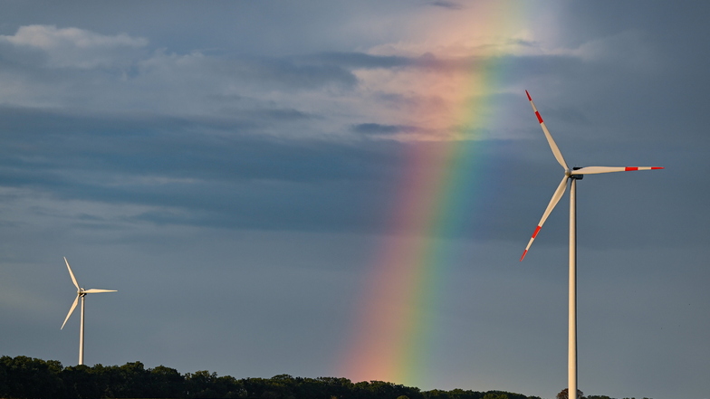 Ein Regenbogen spannt sich über zwei Windenergieanlagen in einem Windpark im Landkreis Oder-Spree. Deutschland will bis 2045 nur noch so viel Treibhausgas ausstoßen, wie auch wieder gebunden werden kann.