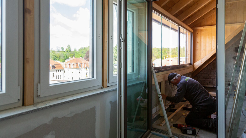 Norbert Müller vom Holzbau Dresden beim Arbeiten in einer Dachwohnung, die einen schönen Blick ins Erzgebirge bietet.