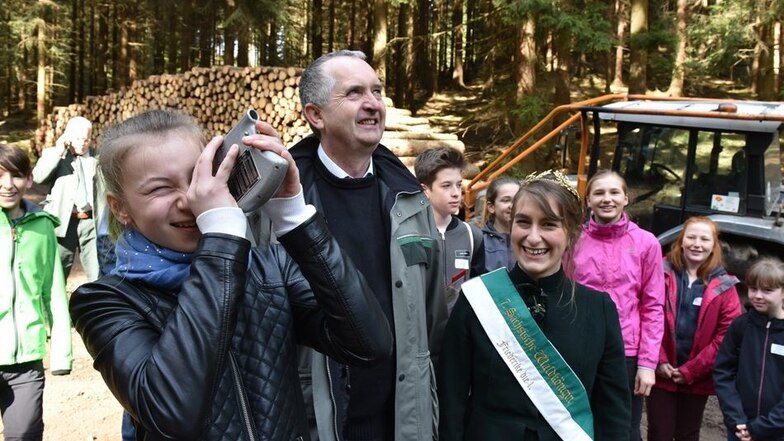 So wird die Höhe der Bäume gemessen: Sachsens Waldkönigin Friederike Binder und Minister Thomas Schmidt sehen zu, wie Nele aus der 6. Klasse die Höhe einer Fichte bestimmt.