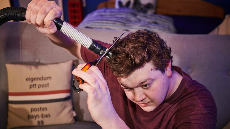Joshua Otto, ein Tischler in der Ausbildung, schneidet sich im Lockdown die Haare selber. Er nutzt dazu einen Staubsauger mit Abstandhalter, um die Haare alle gleich lang zu schneiden.