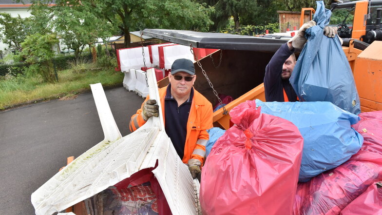 Straßenwärter Holger Zschiedrich (l..) und Jürgen Lindner haben die gefüllten Müllsäcke im Freitaler Stadtgebiet eingesammelt und laden sie am Bauhof ab.