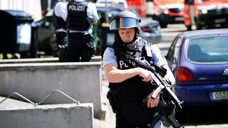 Einsatzkräfte der Polizei stehen vor einem Haus in Köln. Eine Frau soll in einer Kölner Arztpraxis mehrfach mit einer Schreckschusspistole geschossen haben.