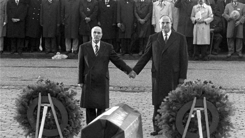 Historische Geste: Der französische Staatspräsident Francois Mitterrand [l] und Bundeskanzler Helmut Kohl reichen sich am 22.9.1984 über den Gräbern von Verdun die Hand.