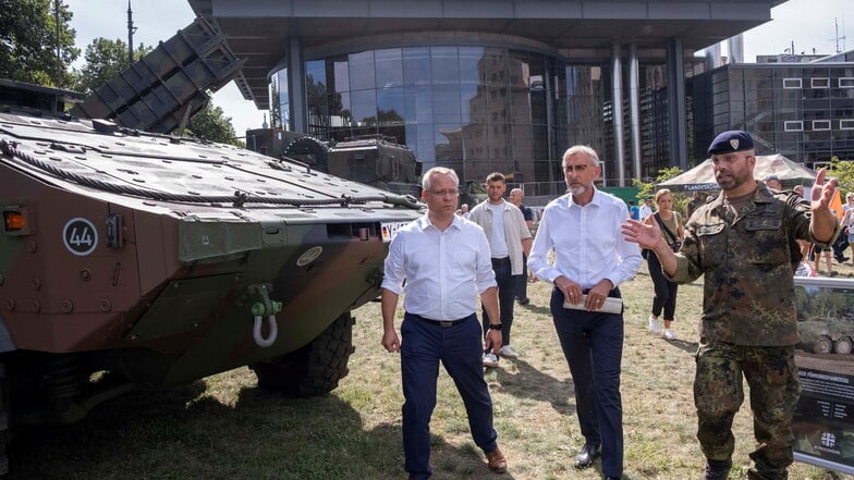 Innenminister Armin Schuster (Mitte) auf dem Stadtfest neben dem umstrittenen Panzer.