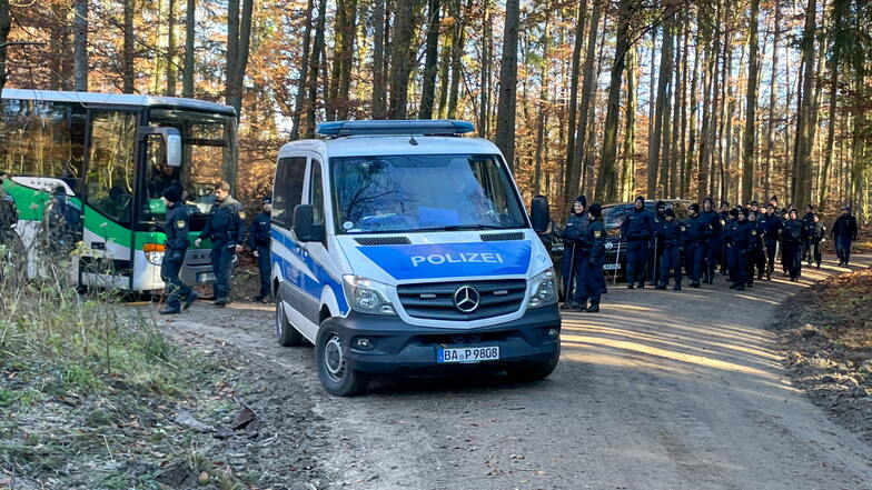 Polizisten und Einsatzfahrzeuge stehen in einem Waldstück. Dort wurde am Dienstag ein Knochen der seit 1995 vermissten Sonja Engelbrecht gefunden.