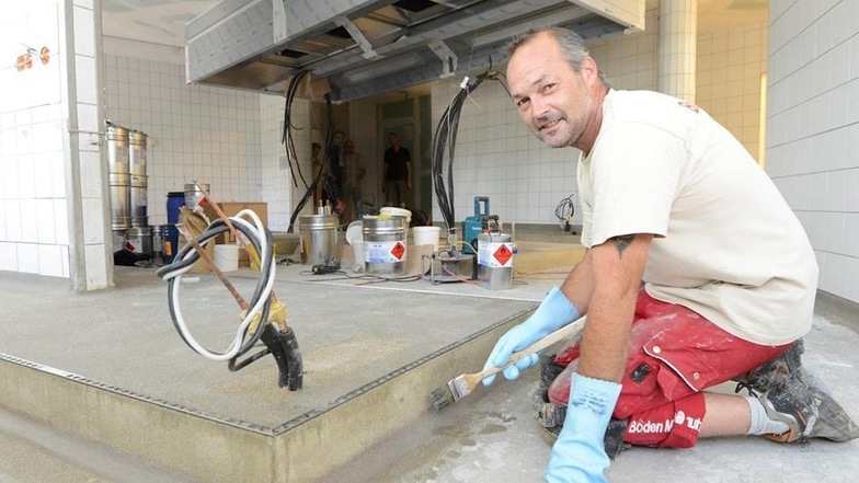 Silvio Geisler, Fußbodenleger aus Sandersdorf in Sachsen-Anhalt, arbeitet in der im Bau befindlichen Küche des Raupennestes in Altenberg am Fußboden.