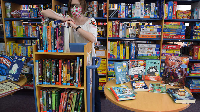 Pia Gutsche am Buchsommer-Regal in der Brigitte-Reimann-Bibliothek in Hoyerswerda: Hier können Leser im Alter zwischen sechs und 17 Jahren auch ohne Bibo-Ausweis Bücher entleihen.