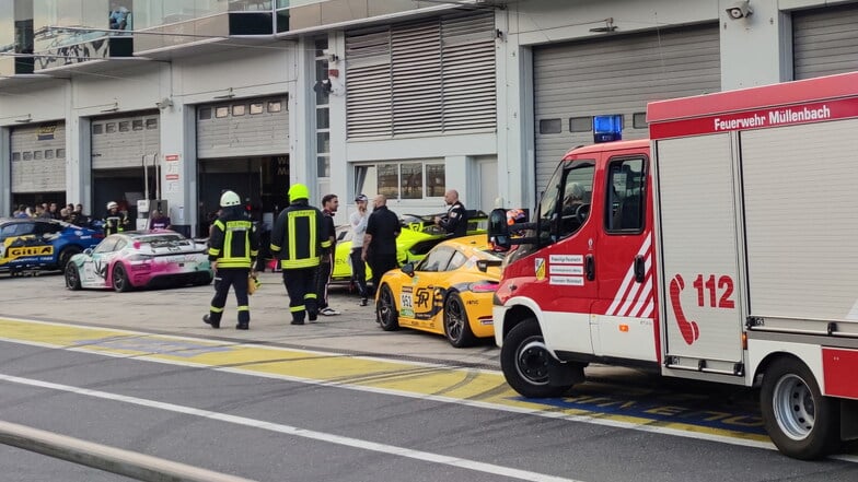 Feuerwehrleute in der Boxengasse des Nürburgrings:  Bei der Explosion einer Druckluftflasche  wurden etliche Menschen verletzt.