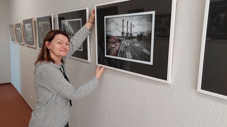 Bibliotheksmitarbeiterin Birgit Herold beim Aufhängen der Bilder. Ab 26. Januar 2022 sind die Fotografien in den Kunstgängen zu sehen.