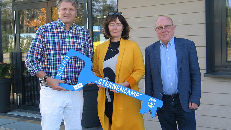 Schlüsselübergabe vor der Sternencamp-Rezeption: Die neuen Betreiber Peter Hesse und Katrin Fahrland nehmen den symbolischen Schlüssel aus den Händen von Bürgermeister Achim Junker entgegen.