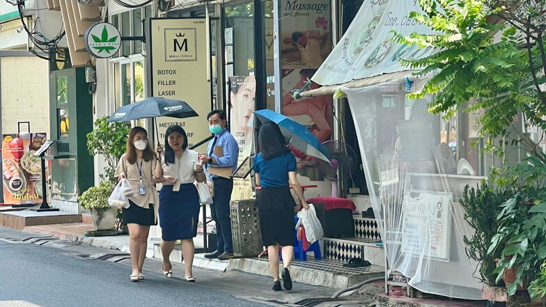 Frauen schützen sich mit Schirmen vor der extremen Hitze in Bangkok. Weite Teile Thailands stöhnen derzeit unter einer extremen Hitzewelle - und ein Ende ist vorerst nicht abzusehen.