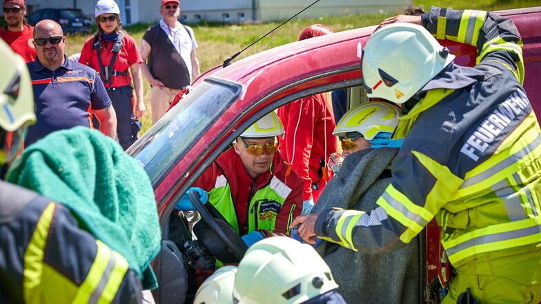 Üben in Neustadt: Rettungskräfte befreien bei einem simulierten Verkehrsunfall einen Verletzten,  "gespielt" von ASB-Praktikant Tom Lachmann (mit Decke).