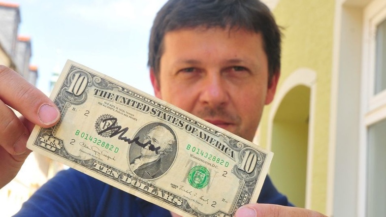 SZ-Redakteur Jörg Richter mit seinem Ali-Dollarschein.