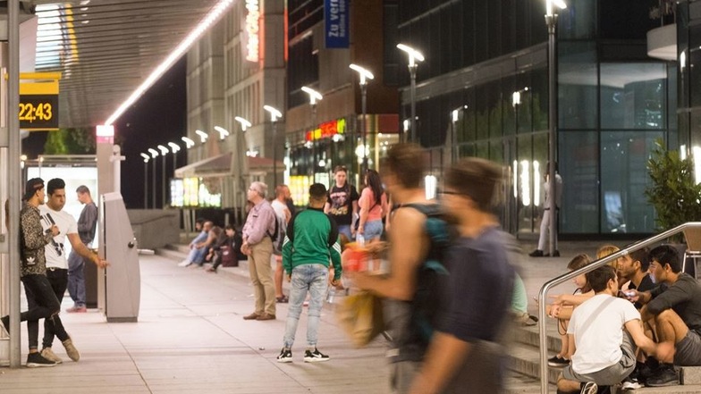 Junge Menschen vertreiben sich die Zeit vor der Bahnstation am Wiener Platz.