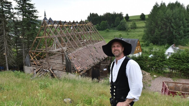 Teilweise ist die historische Scheune in Bärenstein schon abgebaut, vor der Kay Arnswald  steht. Am Dienstag kommt wird das Dachgebälk per Kran  heruntergehoben.