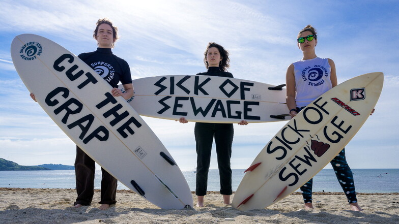 Lucy Luck, Evelyn Hull und Emily van de Geer nehmen an einer Protestaktion der "Surfers Against Sewage" (SAS) in Falmouth teil, die ein Ende der Abwassereinleitungen in die britischen Flüsse und Meere fordern.