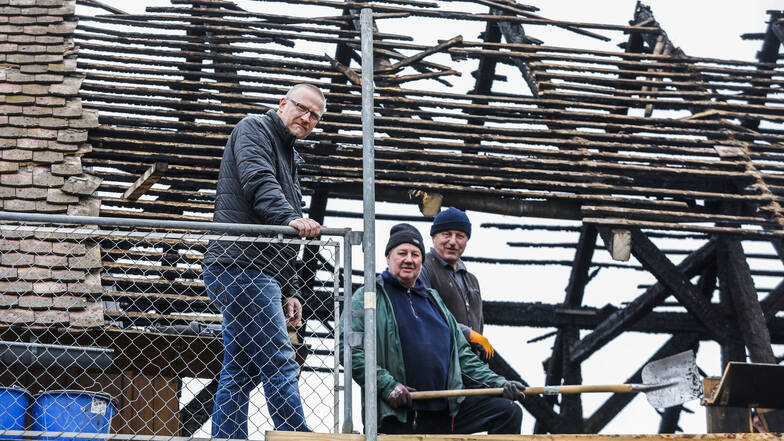 Ullrich Schneider (links), Chef der gleichnamigen Obercunnersdorfer Tischlerei, steht am zerstörten Dach des Werkstatt-Nebengebäudes in Ruppersdorf.