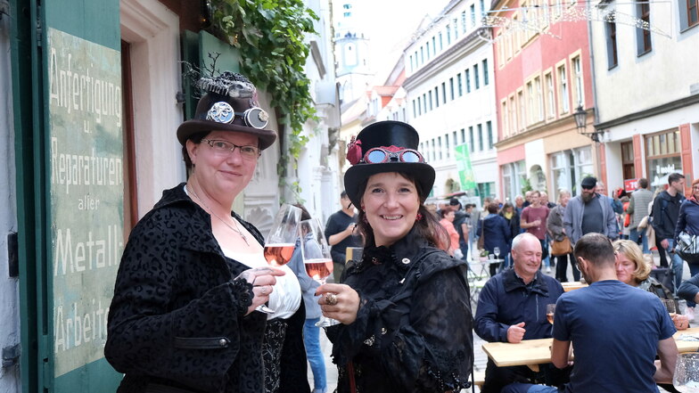 Weinfest 2022: Gina und Ines stoßen vor dem Laden des Vereins "Mit Zahnrad und Zylinder" an.