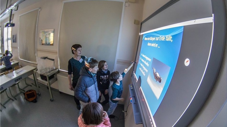 Physiklehrerin Sabine Heinrich (Mitte, hinten) und die zukünftigen Fünftklässler konnten an der Oberschule Niesky die nagelneue interaktive Tafel mit Touchscreen ausprobieren.