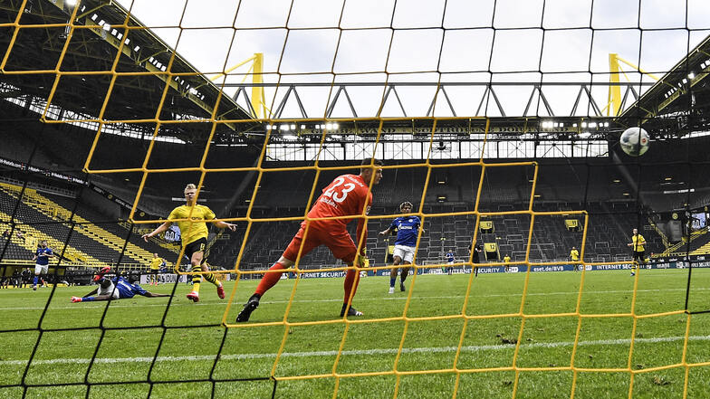Das 1:0 für Dortmund: Erling Haaland (4. v. l.) erzielt das erste Tor in der Bundesliga nach dem Neustart, Schalke-Torwart Markus Schubert (vorn) ist chancenlos. Foto: dpa/Martin Meissner