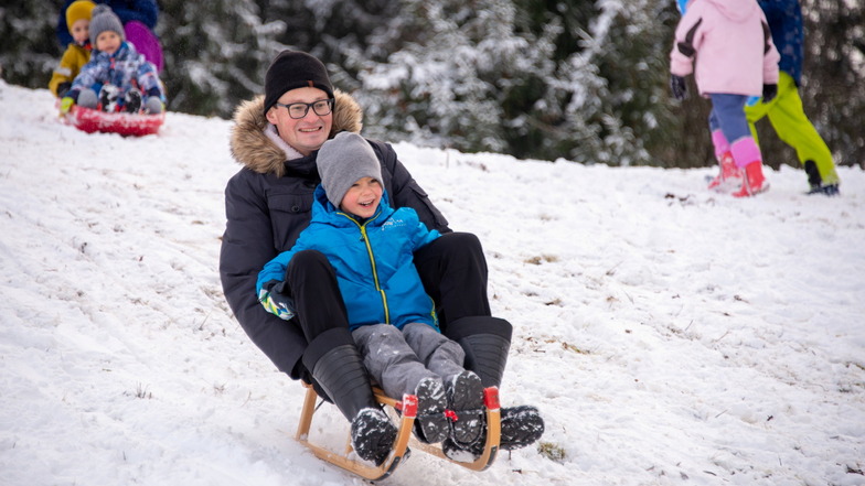Rheinland-Pfalz, Deuselbach: Andreas Walder aus Trier fährt mit Sohn Jakob auf einem Schlitten im ersten Schnee für des beginnenden Winters am Erbeskopf (816 m), dem höchsten Berg in Rheinland-Pfalz.