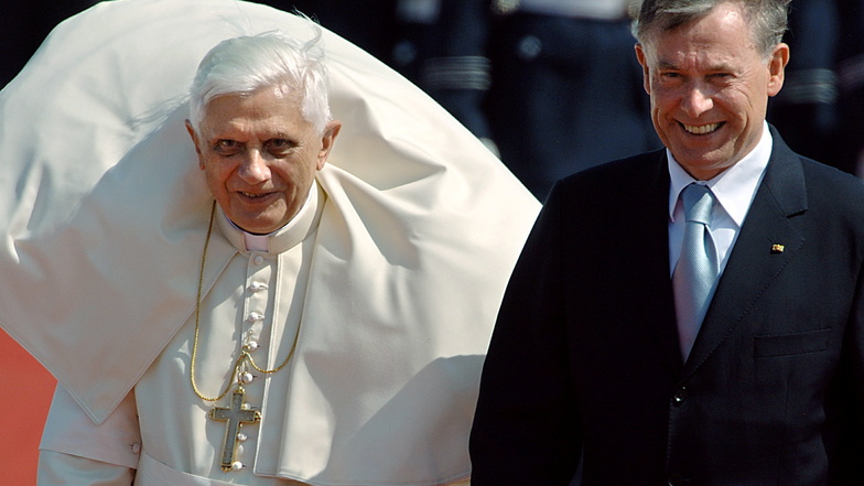 18.08.2005: Der Kragen der Soutane von Papst Benedikt XVI. wird hochgeweht, rechts Bundespräsident Horst Köhler.