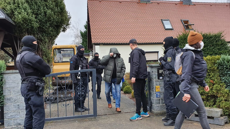 Polizisten vor dem Wohnhaus in Kaditz im Nordwesten Dresdens. Ein Bewohner musste die Beamten zur Vernehmung begleiten.