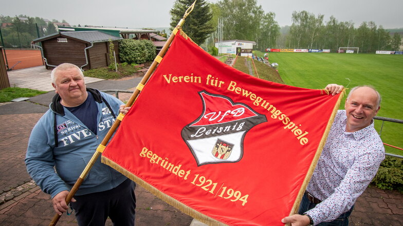 Vereinsmitglied Frank Günther und VfB-Präsident Jörg Lippert (rechts) sind stolz auf die Vereinsfahne. Auch sie zeigt, dass in diesem Jahr ein besonders Jubiläum ansteht, der VfB auf den 100. Jahrestag der Gründung verweisen kann – der Erstgründun