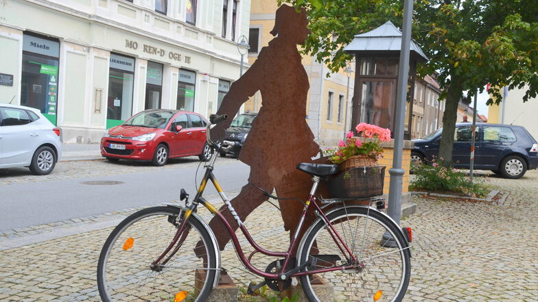 Bunte Tupfen: Eines der beiden mit Blumenkörben bestückten Fahrräder auf dem Marktplatz Reichenbach. Die ehemaligen Geschäfte der Häuser im Hintergrund stehen seit langer Zeit leer.