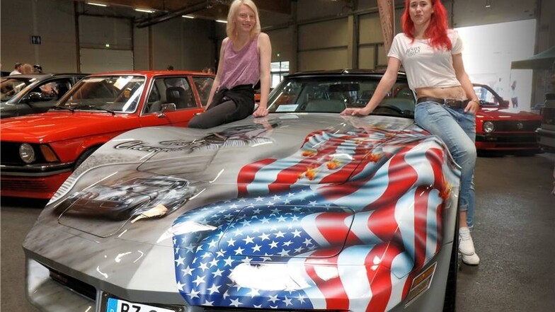 Sophie Schatz (l.) und Emily Franke posieren auf dem Chevrolet Corvette von Carsten Gräubig.