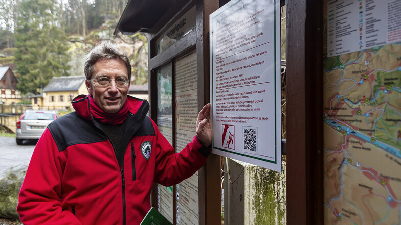 Nationalparksprecher Hanspeter Mayr präsentiert die neuen Gefahrenwarntafeln, wie hier am Parkplatz Neumannmühle im Kirnitzschtal.