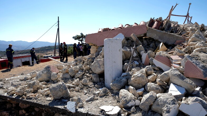 Feuerwehrleute stehen neben der zerstörten Kirche Profitis Ilias.