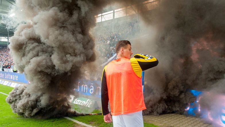 Dynamo-Stürmer Stefan Kutschke steht 2016 in Magdeburg neben Rauchbomben, die Dynamos-Fans in den Innenraum geworfen hatten.