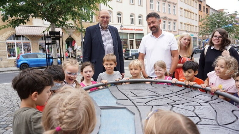 Oberbürgermeister Olaf Raschke (links) und Stadtmarketing-Chef Christian Friedel übergeben das neue Spielgerät in der Neugasse an die Vorschulgruppe des Franziskus Kinderhauses, stellvertretend für alle Meißner Kinder und Gäste der Stadt.